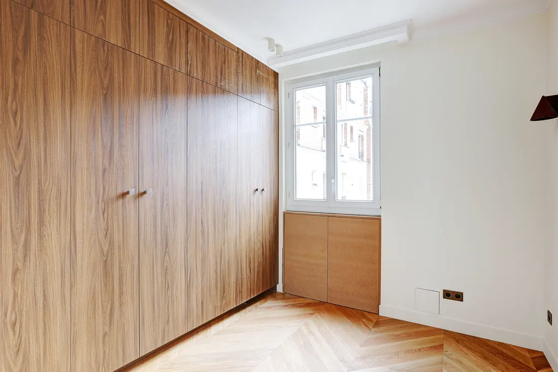 Chambre avec placards toute hauteur en noyer et rangement sous fenêtre