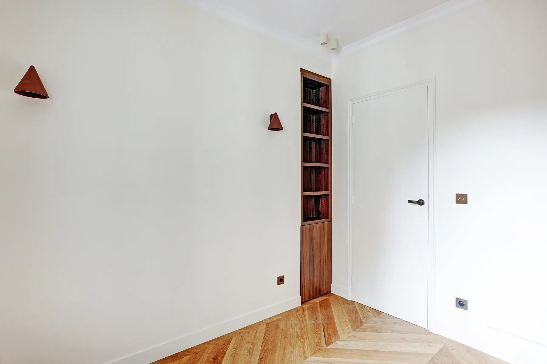 Couloir peint avec niche verticale en noyer, appliques murales et porte à âme pleine