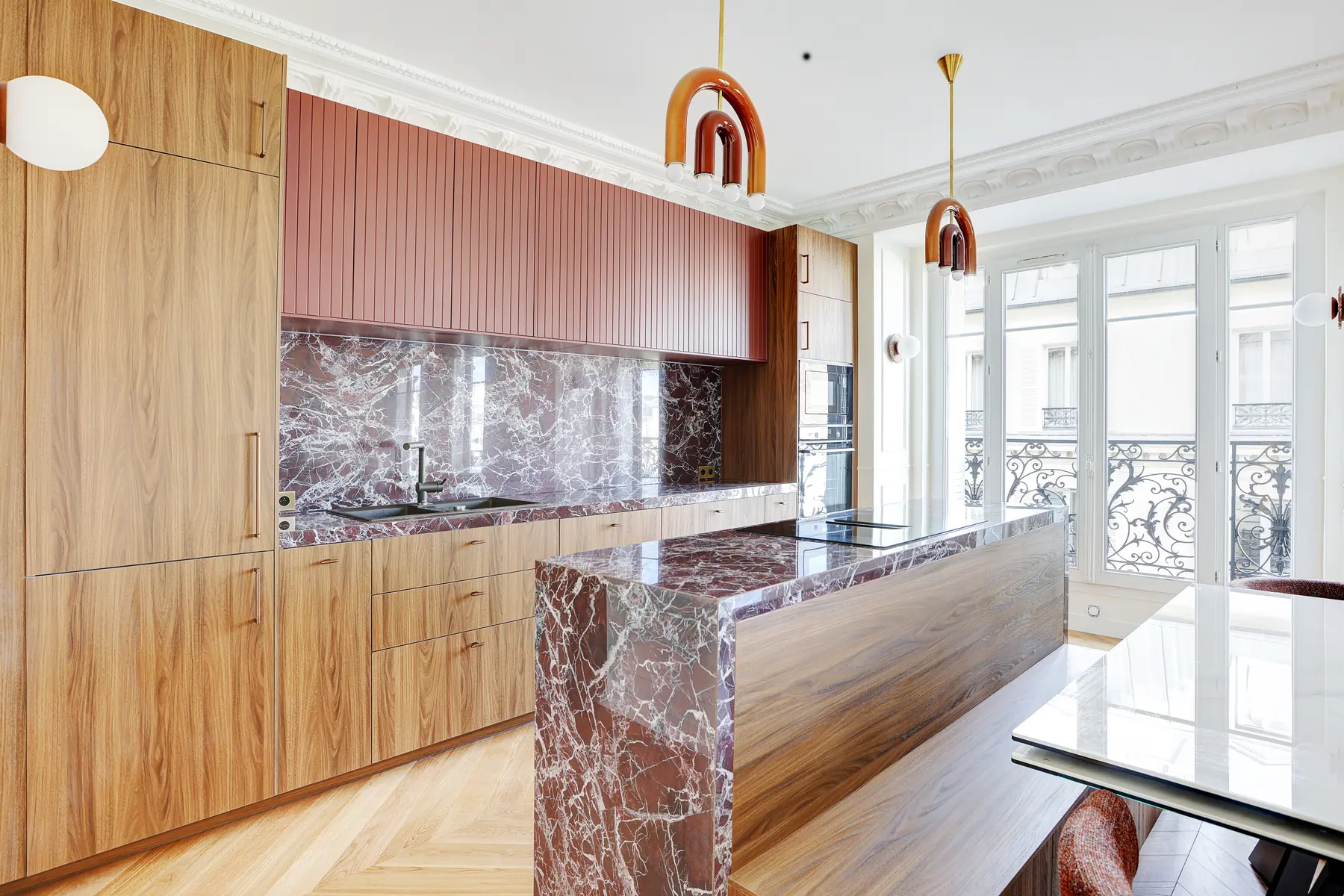 Cuisine sur mesure en noyer avec plan et crédence en marbre rouge, dans un appartement haussmannien rénové à Paris